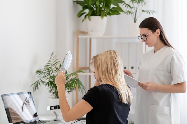 鏡でフケの問題を抱えている女性