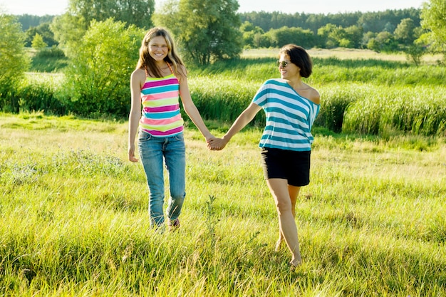 Woman with daughter teen walking in nature