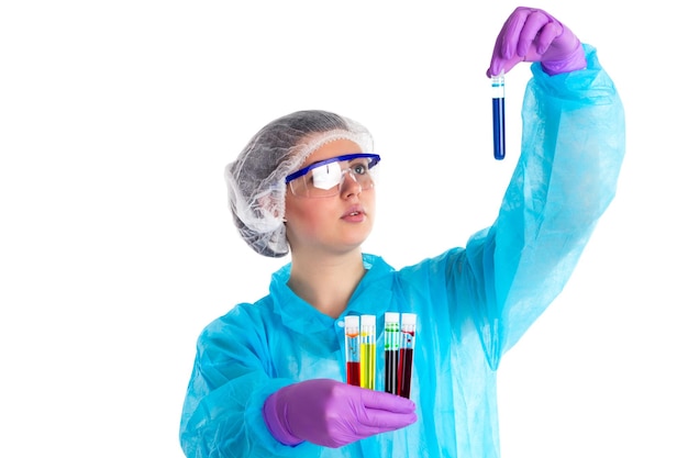 The woman with different tubes is focusing on a navy liquid in a tube on a white background.