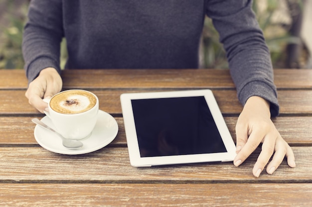 Woman with digital tablet and coffee cup