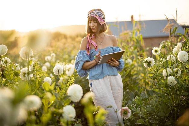 Woman with a digital tablet on flower farm outdoors