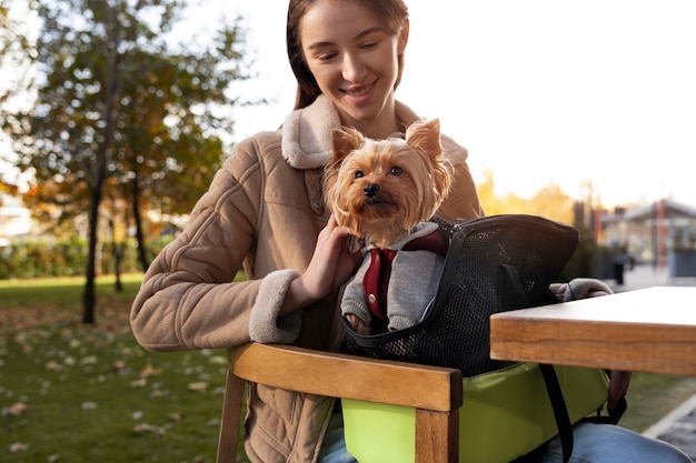 Foto donna con cane in borsa vista frontale