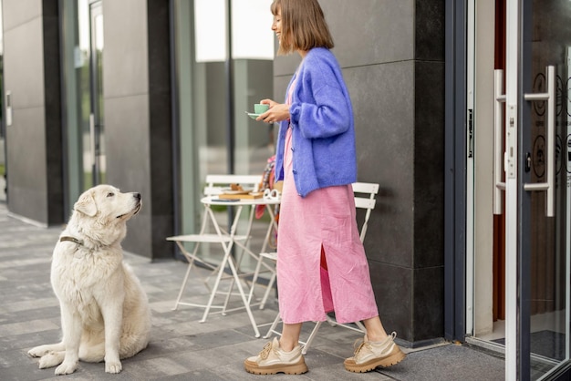 屋外のカフェで犬と一緒にいる女性