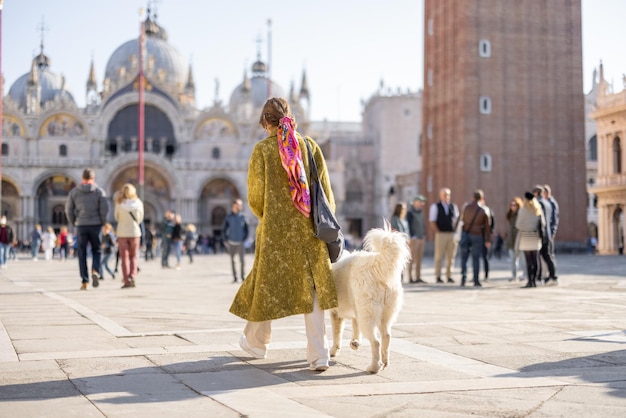 イタリア、ヴェネツィアの中央広場に犬を連れた女性