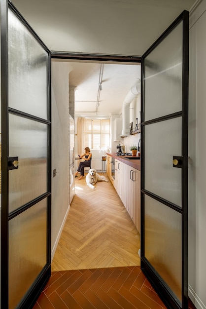 Woman with dog at kitchen in stylish apartment