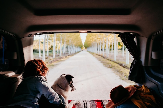 Photo woman with dog lying in camper trailer