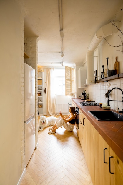 Woman with dog in modern and stylish kitchen