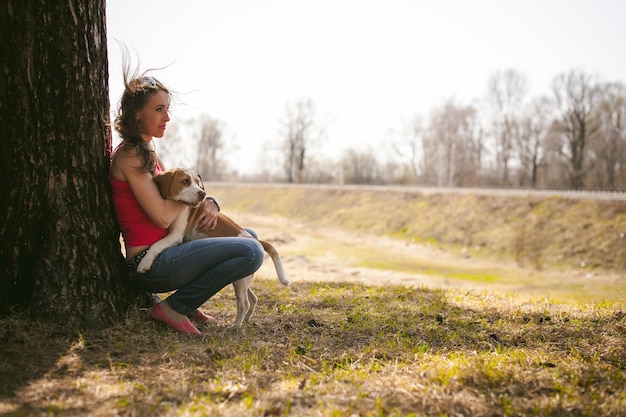 Foto donna con il cane seduta sul campo contro il cielo