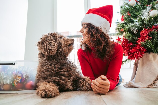 Photo woman with dog sitting at home christmas day