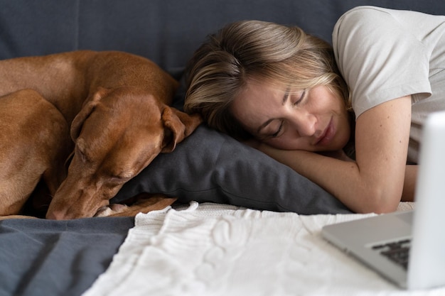 Foto donna con il cane che dorme sul divano