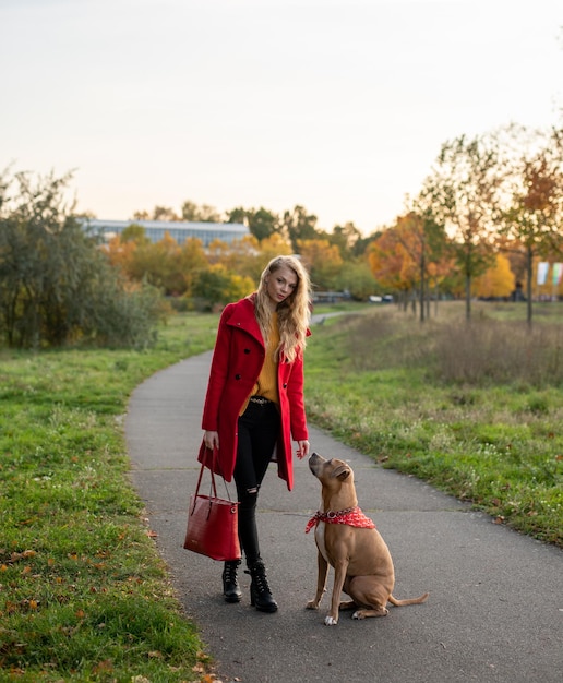 Foto donna con il cane che cammina per strada