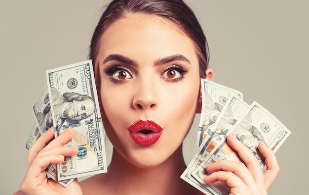 Woman with dollars in hand Portrait woman holding money banknotes Girl holding cash money in dollar banknotes Woman holding lots of money in dollar currency Luxury beauty and money concept