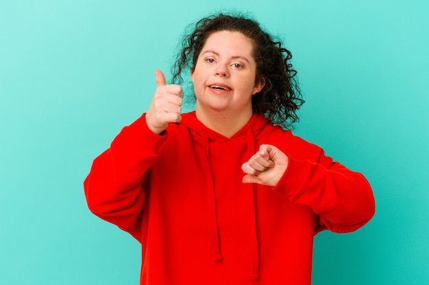 Женщина с синдромом Дауна изолирована, показывает палец вверх и палец вниз, трудно выбрать концепцию