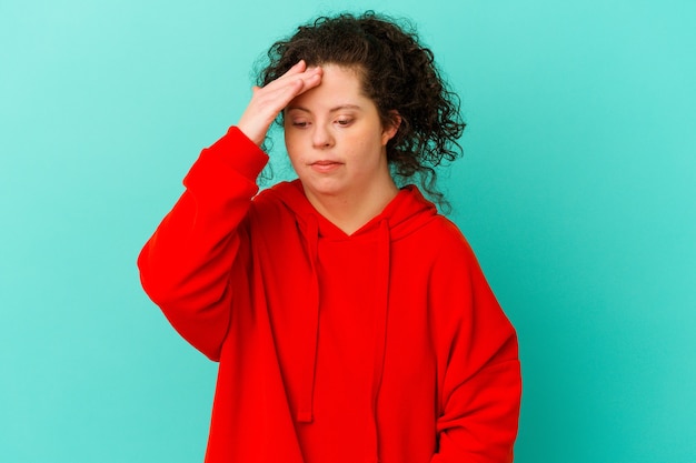 Woman with Down syndrome isolated touching temples and having headache.