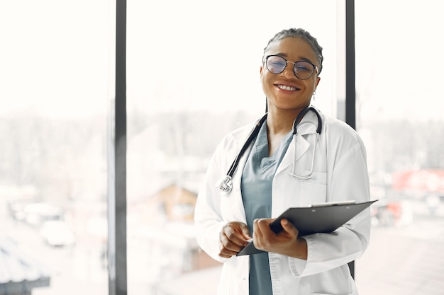 Photo woman with dreadlocks. dark skinned doctor. woman in a hospital gown.