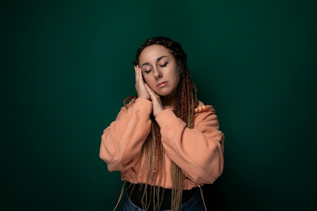 Woman with dreadlocks holding head in hands