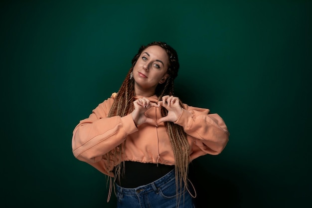 Woman with dreadlocks standing in front of green wall