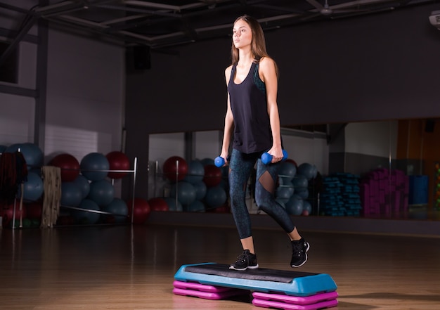 Woman with dumbbells in gym