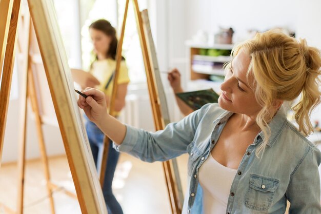 Foto donna con un disegno a cavalletto nello studio della scuola d'arte