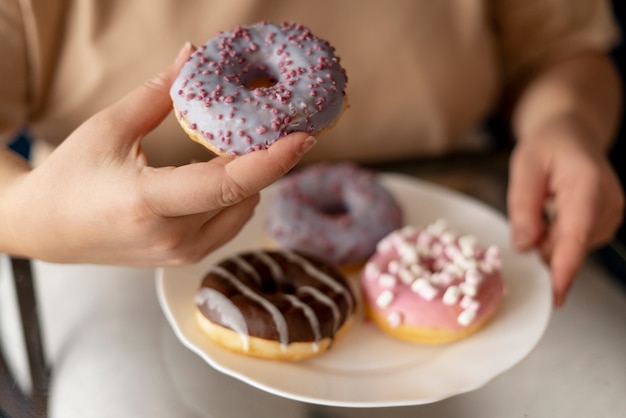 Donna con disturbi alimentari che prova a mangiare ciambelle