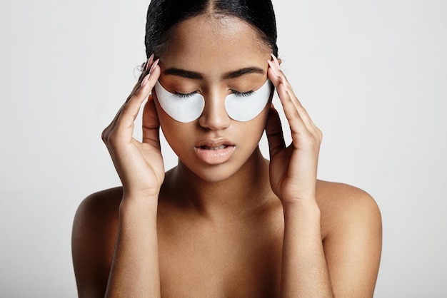 Woman with an eye patches touching temples skin stress concept