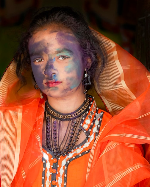 A woman with face paint and a scarf on her head