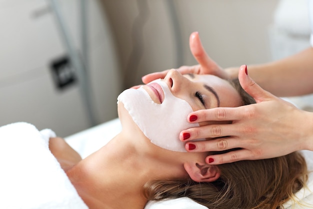 woman with facial mask in beauty salon