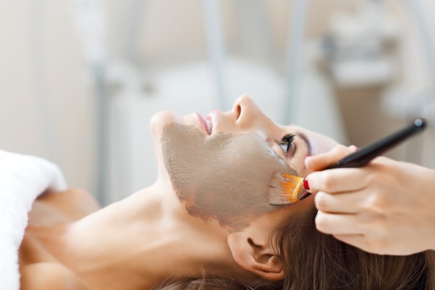 woman with facial mask in beauty salon