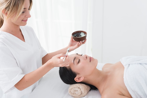 Foto donna con una maschera facciale in una spa