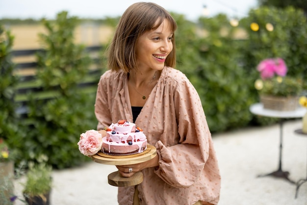 Woman with festive cake in garden