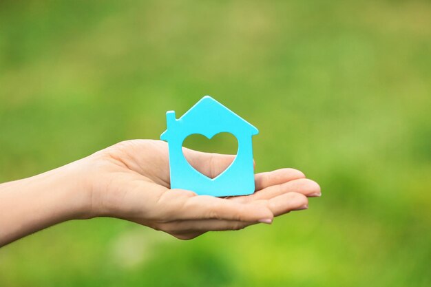 Woman with figure of house on blurred background