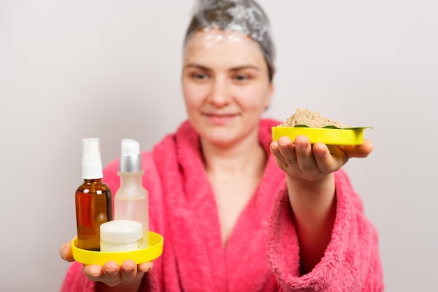 A woman with a film on her head makes a hair mask