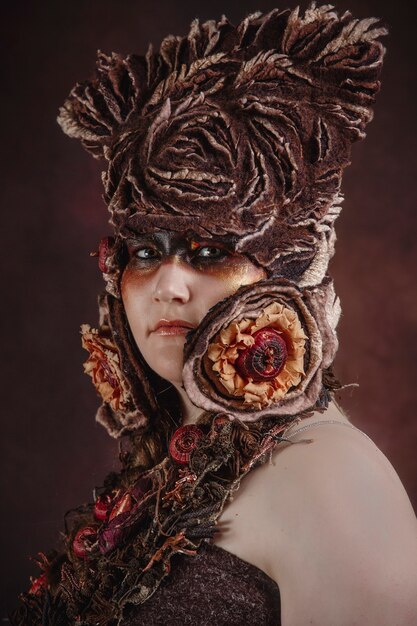 Foto donna con cappello floreale su una stanza buia