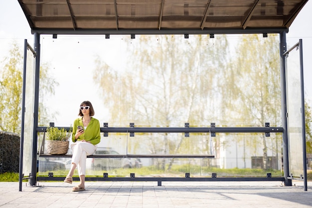 Woman with flowerpot at modern bus stop