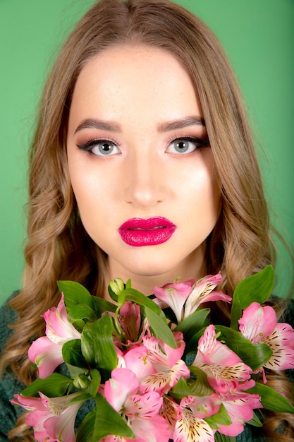 Woman with flowers on green background