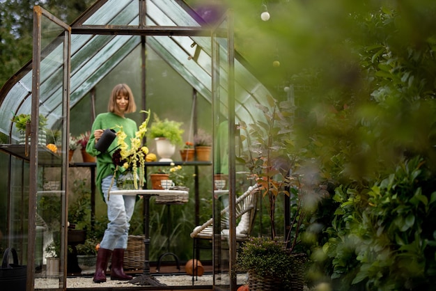 Photo woman with flowers in greenhouse