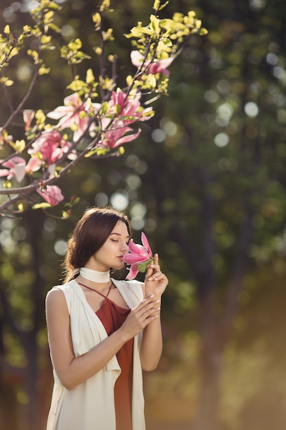 屋外の花を持つ女性