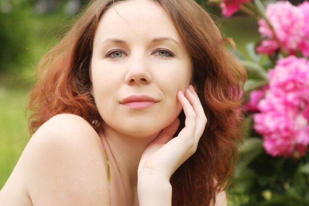 Woman with flowers posing in summer park