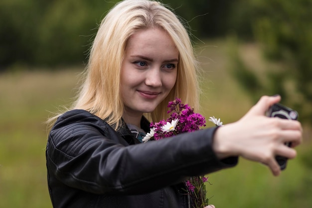 Woman with flowers taking selfie through mobile phone