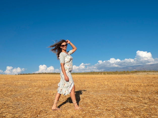 Woman with flying hair in golden field