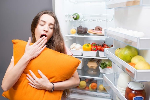 Woman with food near refrigerator