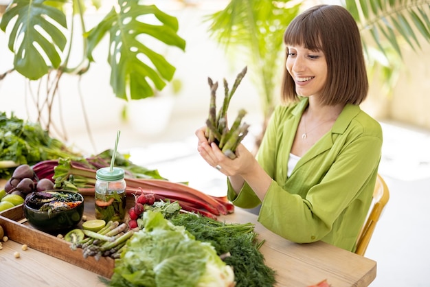 Женщина со свежими здоровыми пищевыми ингредиентами в помещении