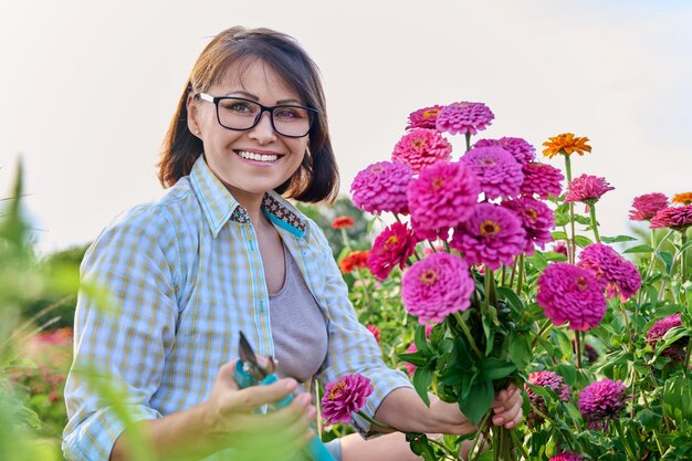 사진 꽃이 피는 정원 밖에서 신선 한 zinnia 꽃 을 가진 여자