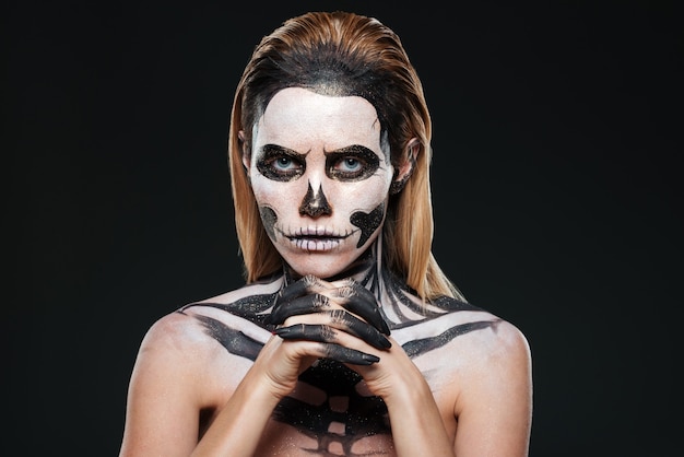 Фото Женщина с пугающим макияжем скелета на черном фоне