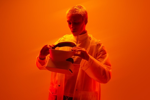 Woman with futuristic VR glasses in orange studio
