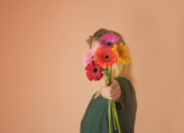 ガーベラの花の花束を持つ女性