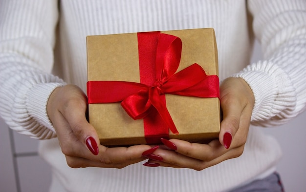 Woman with gift box close up. Good New Year spirit. Selective focus