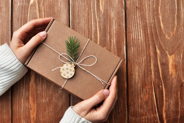 A woman with a gift box in her hand packaging of new year\'s\
gifts