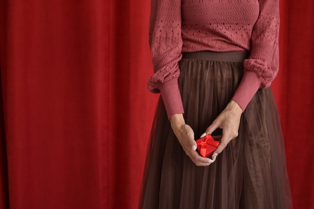 Donna con confezione regalo su sfondo rosso
