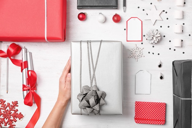 Woman with gift boxes and Christmas decorations at table